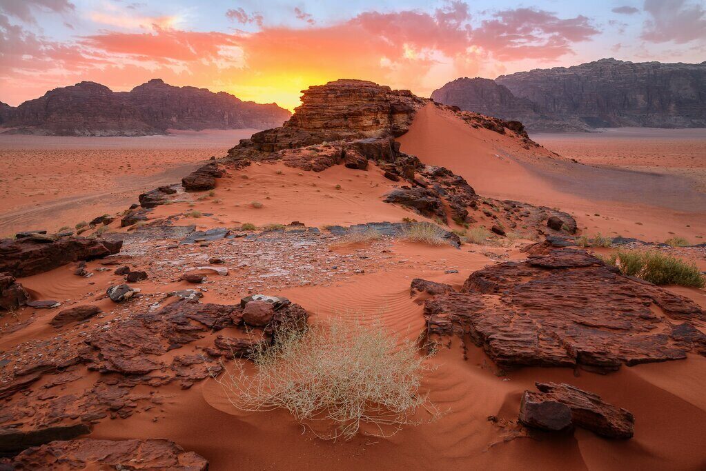 Zonsopkomst boven rotsen en zandduinen in Wadi Rum
