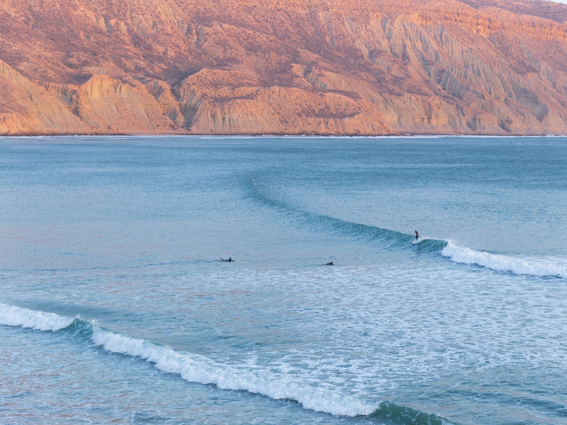 Surfers op de golven bij Taghazout aan de Atlantische kust van Marokko