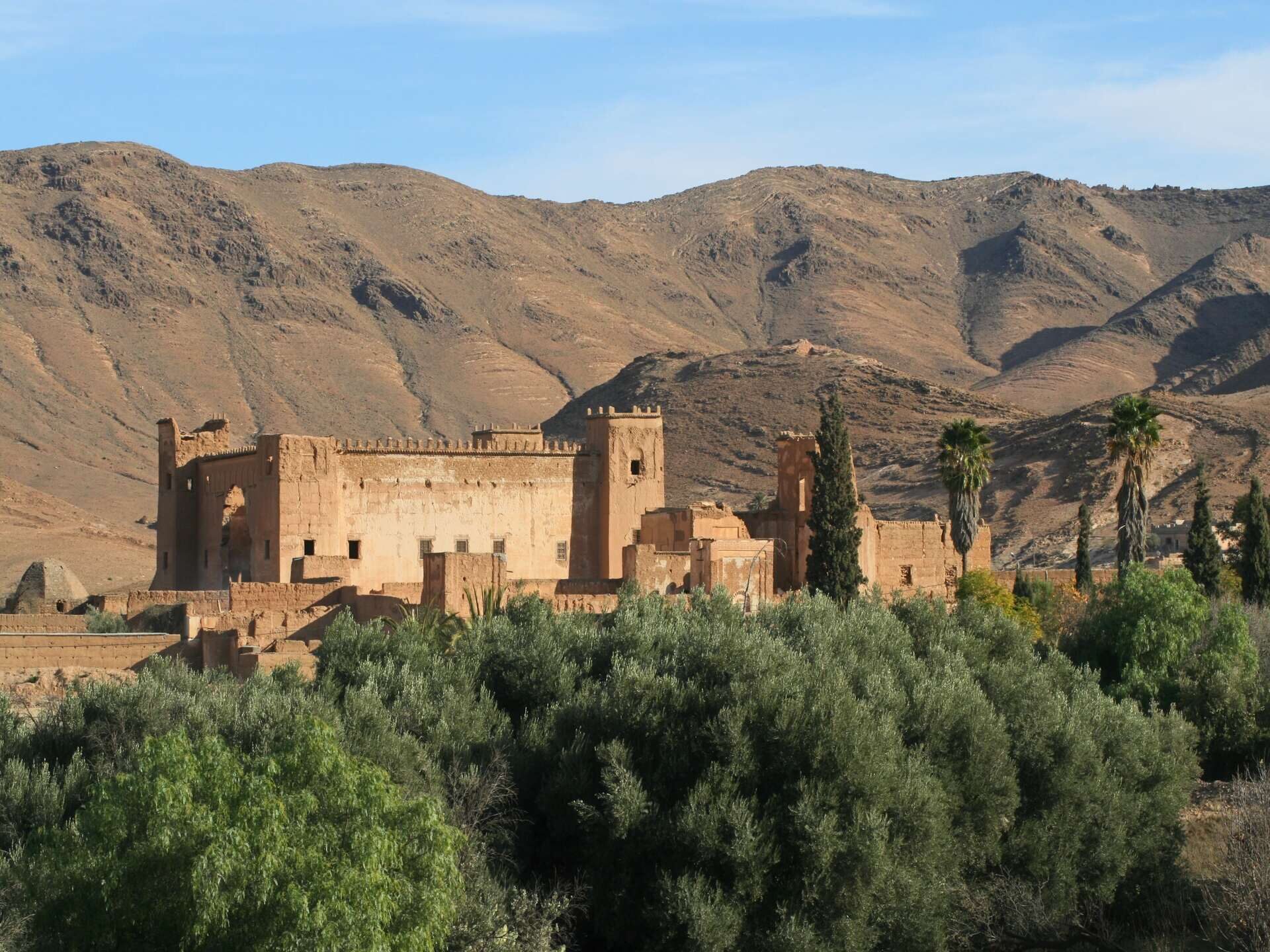 Kasbah bij Taliouine in de Anti-Atlas, Marokko, omringd door bergen en palmbomen