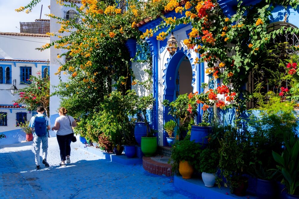Blauwe straat in Chefchaouen met bloemen en traditionele huizen