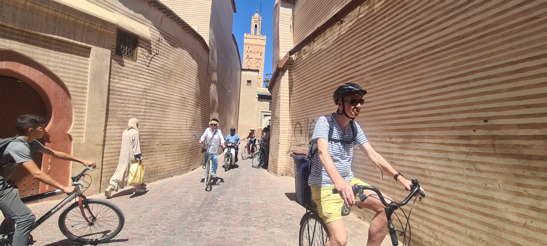 Fietsers in een smalle straat in de medina van Marrakech, Marokko