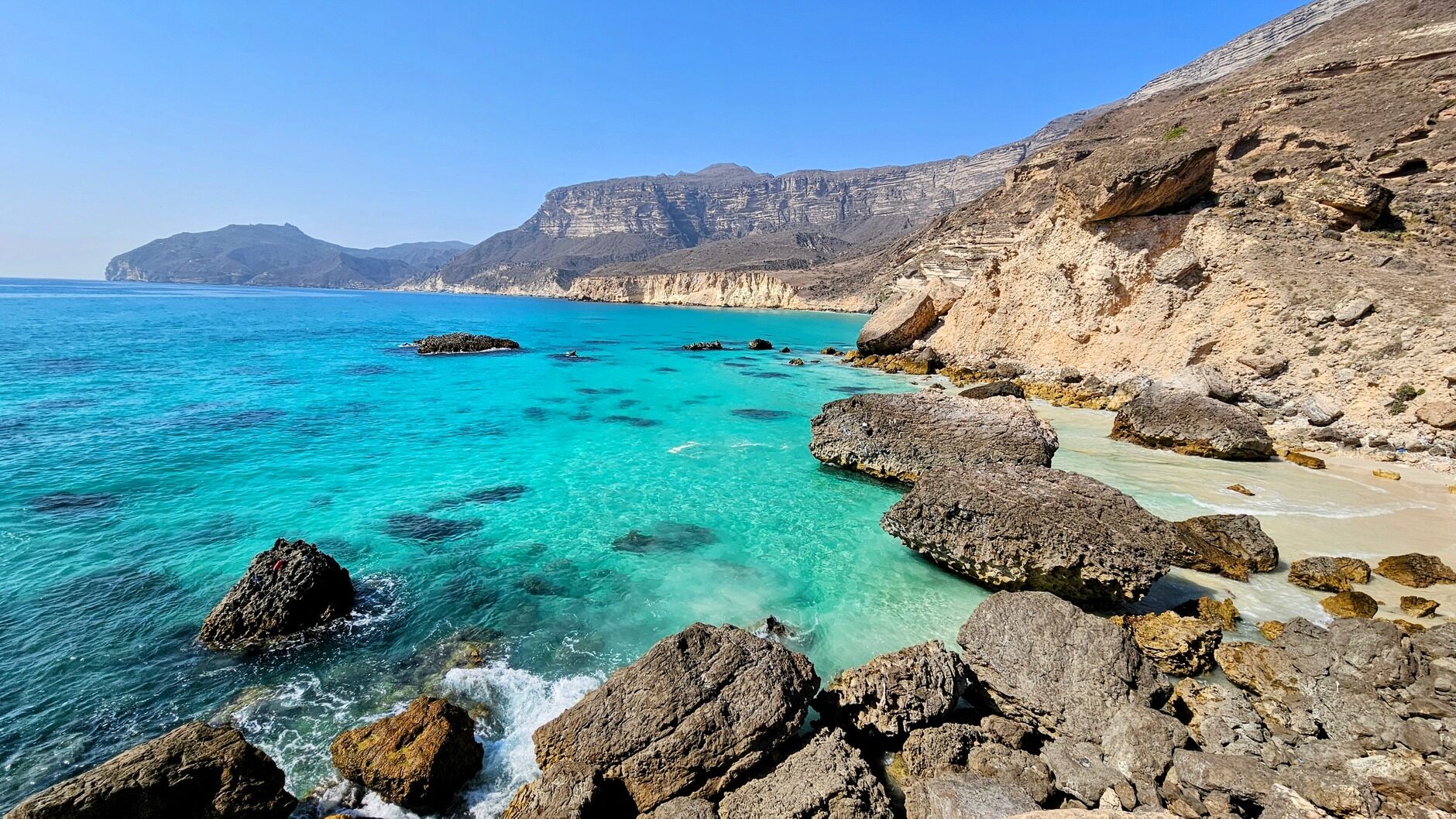 Turquoise zee en rotsachtige kustlijn in Oman