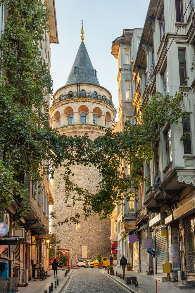 Galatatoren gezien vanuit een straat in Galata met gevels en klimop op de voorgrond