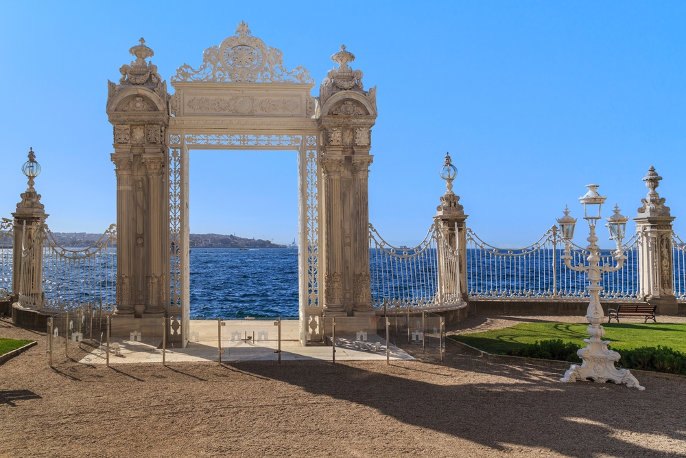Marmeren waterpoort van het Dolmabahçe paleis aan de Bosporus met sierhek en lantaarns