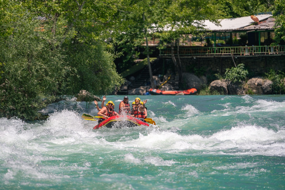 Groep met helmen en zwemvesten raft door de stroomversnellingen van de Köprüçay bij het basisstation